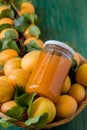 Close up of organically grown apricots and jar of apricot jam. Basket full of apricots on green wooden background Royalty Free Stock Photo