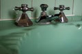 Close up of original green vintage retro 1930s deco wash basin and stainless steel taps. Royalty Free Stock Photo