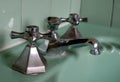 Close up of original green vintage retro 1930s deco wash basin and stainless steel taps. Royalty Free Stock Photo