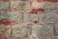 Very original texture of a stone wall fixed by red cement