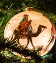 Close up of ornament of three wise men on a lit Christmas tree