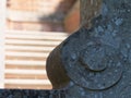 Close-up of ornamental stone element of a formal garden. Blurred stairs in the background.