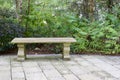 Close up of an ornate carved bench on a stone patio in a European garden