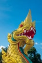A close up of ornate green, gold and red naga statue in front of the Thai Buddhist temple of Wat Kaew Korawaram in Krabi, Thailand
