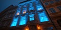 close up of ornate office building illuminated with vibrant blue lights at night