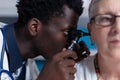 Close up of otology specialist examining ill elderly patient while using otoscope Royalty Free Stock Photo