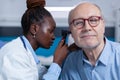 Close up of otology specialist examining senior person using otoscope Royalty Free Stock Photo