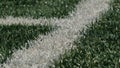 Close up of the out of bounds line on a turf football field.