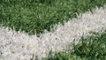 Close up of the out of bounds line on a turf football field.