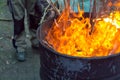 Close up of outdoor fire by burning branches in oil barrel. Royalty Free Stock Photo