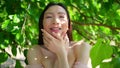 Close up outdoor portrait Beautiful young Chinese Asian woman perfect skin posing outside sunny summer day green foliage