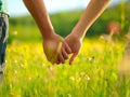 Close up outdoor portrait of couple holding hands in the chamomile field. Love concept