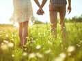 Close up outdoor portrait of couple holding hands in the chamomile field. Love concept