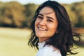 Close-up outdoor portrait of happy beautiful smiling young woman with windy hair and freckles, enjoying the warm weather, posing Royalty Free Stock Photo