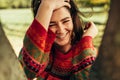 Close-up outdoor portrait of happy brunette young woman with freckles smiling and enjoying the weather, wearing sweater on nature Royalty Free Stock Photo