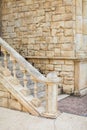 Close up outdoor view of small and narrow stone stairecase. aged sand color steps jointed to brick wall in public park Royalty Free Stock Photo