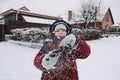 Close up outdoor winter portrait of boy playing snowballs. Authentic, real, candid portrait of cute boy in winter time