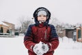 Close up outdoor winter portrait of boy playing snowballs. Authentic, real, candid portrait of cute boy in winter time