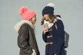 Close-up of an outdoor winter portrait of two teenage girls students in a profile smiling and talking