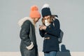 Close-up outdoor winter portrait of two teenage girls students in profile smiling and talking, girls looking at mobile phone Royalty Free Stock Photo