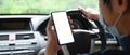 Over shoulder view of young man using mobile phone while driving car. Royalty Free Stock Photo