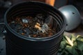 close-up of overflowing garbage can, with flies and in the trash