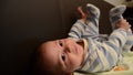 Close up overhead shot of baby boy on the soffa playing with his feet