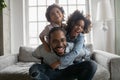 Close up overjoyed African American man piggy backing kids