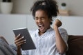 Close up overjoyed African American woman celebrating success, holding tablet Royalty Free Stock Photo