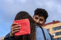 Close up overjoyed man hugging girlfriend, thanking for romantic present, surprise, happy attractive young woman holding gift box