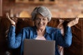 Close up overjoyed mature woman wearing glasses looking at laptop