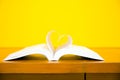 Close up page of a book in heart shape on the table at library Royalty Free Stock Photo