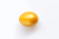 Close-up painted golden egg settled in the middle of white background, top view.