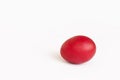 Close-up painted red egg settled in the middle of white background. Royalty Free Stock Photo