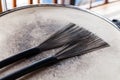 Close-up of a pair of black drum brushes on a white shabby drum. Concept concert, live music, performance, musical evening in a