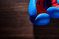 Close-up of a pair of boxing blue and red gloves hanging on the wooden wall.