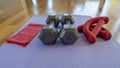Close up of a pair of dumbbells, theraband exercise bands, and a yoga mat on hardwood floor