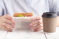 Close up on pair of female hands removing a healthy wholesome wholemeal bread ham sandwich from her lunch box during lunch break