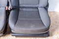 A close-up of a pair of front seats covered in gray fabric with a curly pattern with plastic seat belt locks taken before Royalty Free Stock Photo