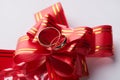 Close-up of pair Gold Wedding rings on red wedding ribbon bow Royalty Free Stock Photo