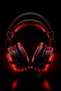 Close up of pair of headphones on black background with red light