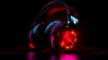 Close up of pair of headphones on black background with red light