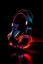 Close up of pair of headphones on black background with red light