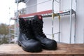 Close-up of pair of new black work boots made of leather with reinforced cape, high top on construction site, concept of special Royalty Free Stock Photo