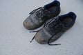 close-up of pair old scratched, dirty black Safety Shoes, shabby work leather boots with laces on light gray floor, concept of Royalty Free Stock Photo