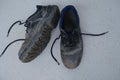 Close-up of pair old scratched, dirty black Safety Shoes, shabby work leather boots with laces on light gray floor, concept of Royalty Free Stock Photo