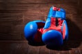 Close-up of the pair of red and blue boxing gloves on the wooden plank. Royalty Free Stock Photo