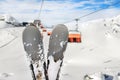 Close-up pair of skis on mountain winter resort with ski-lift and beautiful winter mountain panoramic scenic view