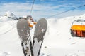 Close-up pair of skis on mountain winter resort with ski-lift and beautiful winter mountain panoramic scenic view