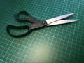 Close up of a pair of stainless steel metal scissors on a cutting mat